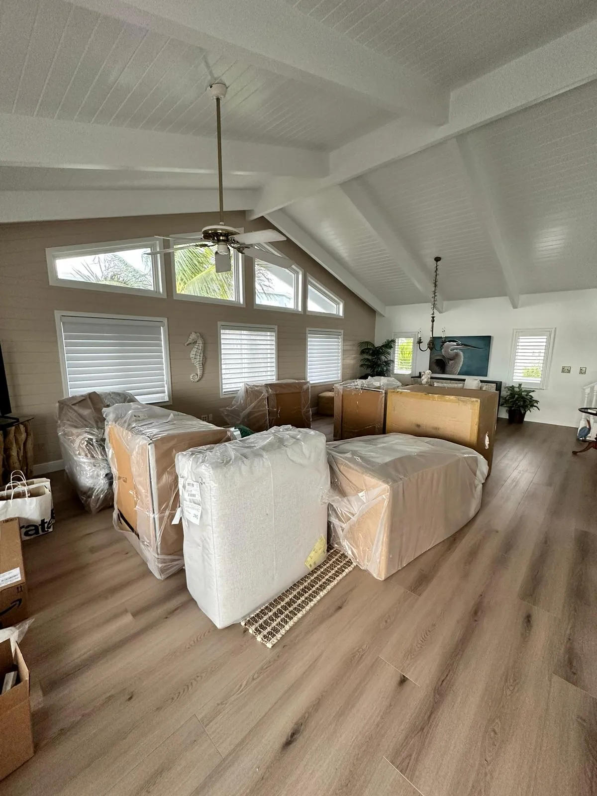 Living room with furniture fully wrapped in pads and shrink wrap