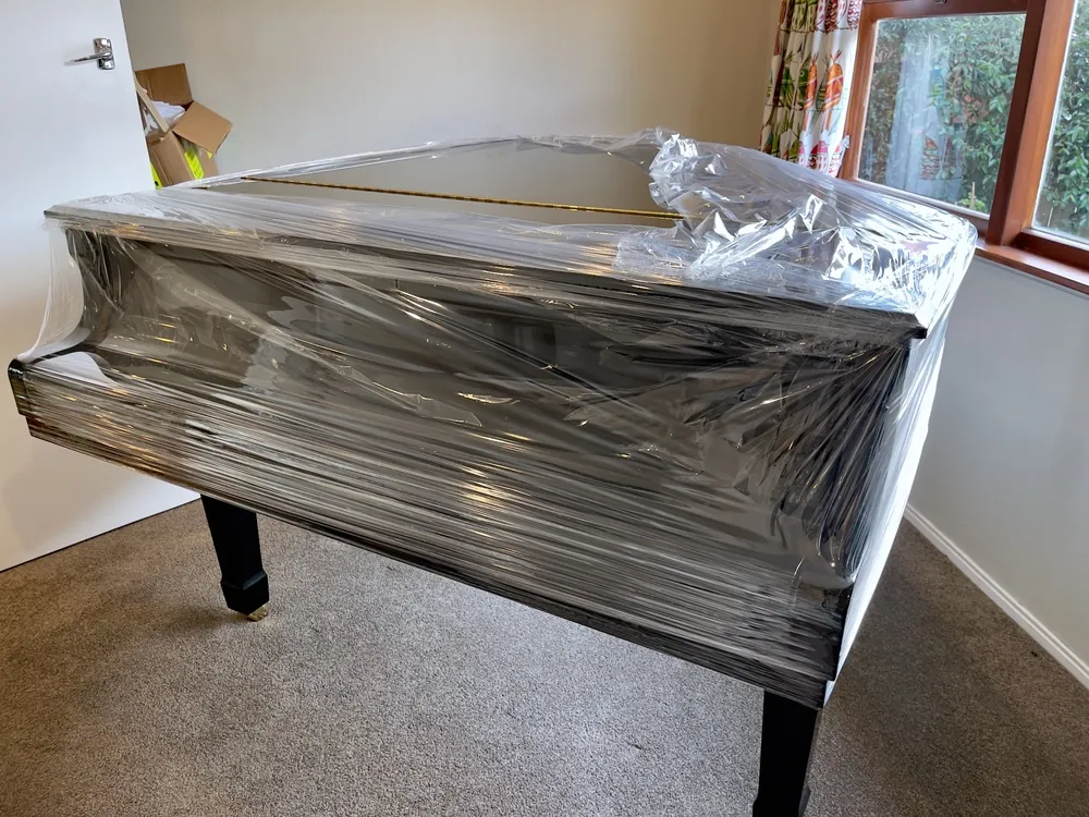 Shrink-wrapped piano in a living room